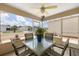 The screened-in lanai features a ceiling fan and a glass top table with seating for four at 2805 Burgos Dr, The Villages, FL 32162