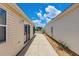 A glimpse between homes, showcasing well-kept exteriors and a clear pathway at 2805 Burgos Dr, The Villages, FL 32162