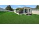 Spacious backyard with lush green grass, screened-in lanai, and lounge chairs at 30532 Gidran Ter, Mount Dora, FL 32757