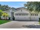 Attractive single-story house with a three-car garage, blue door, and landscaped yard at 30532 Gidran Ter, Mount Dora, FL 32757