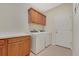 This laundry room is equipped with a washer, a dryer, and overhead cabinets for storage at 30532 Gidran Ter, Mount Dora, FL 32757