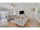Bright living room featuring hardwood floors, ceiling fan, and sliding glass doors to the lanai at 30532 Gidran Ter, Mount Dora, FL 32757