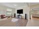 Inviting living room featuring a large TV, hardwood floors, and comfortable seating at 30532 Gidran Ter, Mount Dora, FL 32757