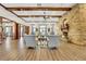 Open lounge area featuring a stone fireplace, high ceilings, and comfortable armchairs at 30532 Gidran Ter, Mount Dora, FL 32757