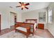 Main bedroom with hardwood floors, ceiling fan, and a view to ensuite bathroom at 30532 Gidran Ter, Mount Dora, FL 32757