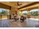 Covered outdoor patio with a stone fireplace, comfortable seating, and scenic views at 30532 Gidran Ter, Mount Dora, FL 32757