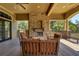 Covered patio with a stone fireplace, comfortable seating, and outdoor living space at 30532 Gidran Ter, Mount Dora, FL 32757