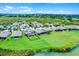 An aerial view of homes with extended patios, lush lawns, and tranquil water views in a picturesque community at 313 Blue Cypress Dr, Groveland, FL 34736