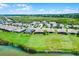 An aerial view showcasing houses with spacious yards and a beautiful water view, complemented by a bright, sunny sky at 313 Blue Cypress Dr, Groveland, FL 34736