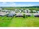 Aerial view of houses with pools and generous lots, complemented by lush landscaping and an expansive green space at 313 Blue Cypress Dr, Groveland, FL 34736