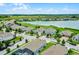 Scenic aerial shot showcasing the desirable neighborhood with houses near a serene lake, lush greenery, and clear blue skies at 313 Blue Cypress Dr, Groveland, FL 34736