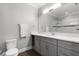 Sleek bathroom with gray vanity, double sinks, modern fixtures, and a glass-enclosed shower at 313 Blue Cypress Dr, Groveland, FL 34736