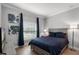 Well-lit bedroom with bed, artwork, and window with blue curtains at 313 Blue Cypress Dr, Groveland, FL 34736