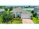 Charming single-story home with a well-manicured lawn, brick driveway, and attached two-car garage at 313 Blue Cypress Dr, Groveland, FL 34736