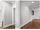 Hallway with fresh gray paint, white trim and wood-look floors leading to an adjacent room at 313 Blue Cypress Dr, Groveland, FL 34736