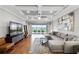 Spacious living room boasts a coffered ceiling, modern furnishings, and sliding glass doors to the outdoor patio at 313 Blue Cypress Dr, Groveland, FL 34736