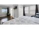 Spacious main bedroom with closet, ensuite bathroom, TV and relaxing reading chair by the window at 313 Blue Cypress Dr, Groveland, FL 34736