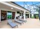 Spacious screened patio featuring a ceiling fan, grill, and outdoor dining area at 313 Blue Cypress Dr, Groveland, FL 34736