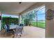 Covered outdoor patio with a dining set, perfect for enjoying meals with a view of the lake at 313 Blue Cypress Dr, Groveland, FL 34736