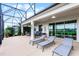 Enjoy outdoor living on the screened patio with lounge chairs and beautiful lake views at 313 Blue Cypress Dr, Groveland, FL 34736
