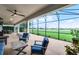 Enjoy lake views from the covered and screened lanai, featuring stylish outdoor furniture at 313 Blue Cypress Dr, Groveland, FL 34736