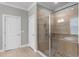 This bathroom features a glass enclosed shower with neutral colored tile and a built-in bench at 313 Blue Cypress Dr, Groveland, FL 34736