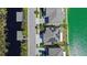 Aerial view of a neighborhood property showcasing the roof, solar panels, landscaping, and waterfront access at 395 Blue Cypress Dr, Groveland, FL 34736