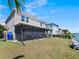 Backyard includes a screened lanai, grass lawn, and waterfront view at 395 Blue Cypress Dr, Groveland, FL 34736