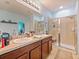 Bathroom featuring double sink vanity with a glass shower at 395 Blue Cypress Dr, Groveland, FL 34736