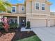 Charming home features a manicured front yard, a covered porch, and a spacious two-car garage at 395 Blue Cypress Dr, Groveland, FL 34736