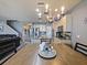 Open concept eat-in kitchen with stainless appliances, granite counters, and chandelier lighting at 395 Blue Cypress Dr, Groveland, FL 34736