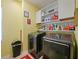 Functional laundry room featuring modern washer/dryer and ample storage shelving at 395 Blue Cypress Dr, Groveland, FL 34736
