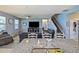 View of the open concept living space with a kitchen island, staircase, and large television at 395 Blue Cypress Dr, Groveland, FL 34736