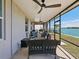 Spacious screened patio overlooking the water with chairs and ceiling fans at 395 Blue Cypress Dr, Groveland, FL 34736