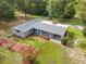 Aerial view of a well-maintained home featuring a landscaped yard with colorful plants and a cozy carport at 4123 County Road 124, Wildwood, FL 34785