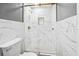 Clean, updated bathroom features walk-in glass shower with marble-patterned tiling and gold hardware at 4123 County Road 124, Wildwood, FL 34785