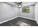 Bright bedroom with wood-look flooring, neutral walls, ceiling fan, and window with backyard view at 4123 County Road 124, Wildwood, FL 34785