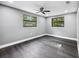 Bright bedroom with neutral walls, wood-look floors, a ceiling fan, and a window with backyard view at 4123 County Road 124, Wildwood, FL 34785
