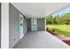 Covered carport featuring a bright blue back door, gray concrete and red accent plants at 4123 County Road 124, Wildwood, FL 34785