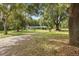 Exterior shot showing a charming home surrounded by mature trees and a lush green lawn at 4123 County Road 124, Wildwood, FL 34785