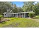 Well-maintained front yard with colorful garden beds framing a charming, single story home at 4123 County Road 124, Wildwood, FL 34785