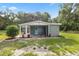 Charming single story home with colorful garden beds and gray exterior paint and a blue door at 4123 County Road 124, Wildwood, FL 34785