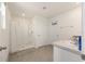 Bright bathroom featuring a walk-in shower, neutral gray tile flooring, and convenient towel hooks at 4713 Sw 86 Ln, Ocala, FL 34476