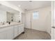 Bathroom featuring double sinks, a large mirror, a walk-in shower, and neutral tile flooring at 4713 Sw 86 Ln, Ocala, FL 34476