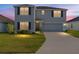 Charming two-story home features a well-maintained lawn, gray exterior, and attached two-car garage at 4713 Sw 86 Ln, Ocala, FL 34476