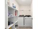 Functional laundry room featuring tile floors, washer, dryer, and shelving at 4713 Sw 86 Ln, Ocala, FL 34476