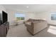 Bright upstairs living room featuring a sectional sofa, swivel chair, and large windows with picturesque views at 4713 Sw 86 Ln, Ocala, FL 34476