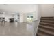 Open-concept living room with tile flooring, a dining area, stairs, and large windows for ample natural light at 4713 Sw 86 Ln, Ocala, FL 34476