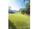 Expansive, lush backyard featuring a well-maintained lawn and a screened-in pool enclosure in the distance at 48 Pinehurst Cir, Ormond Beach, FL 32174
