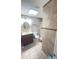 Well-lit bathroom featuring a walk-in shower, neutral tile and vanity storage at 48 Pinehurst Cir, Ormond Beach, FL 32174